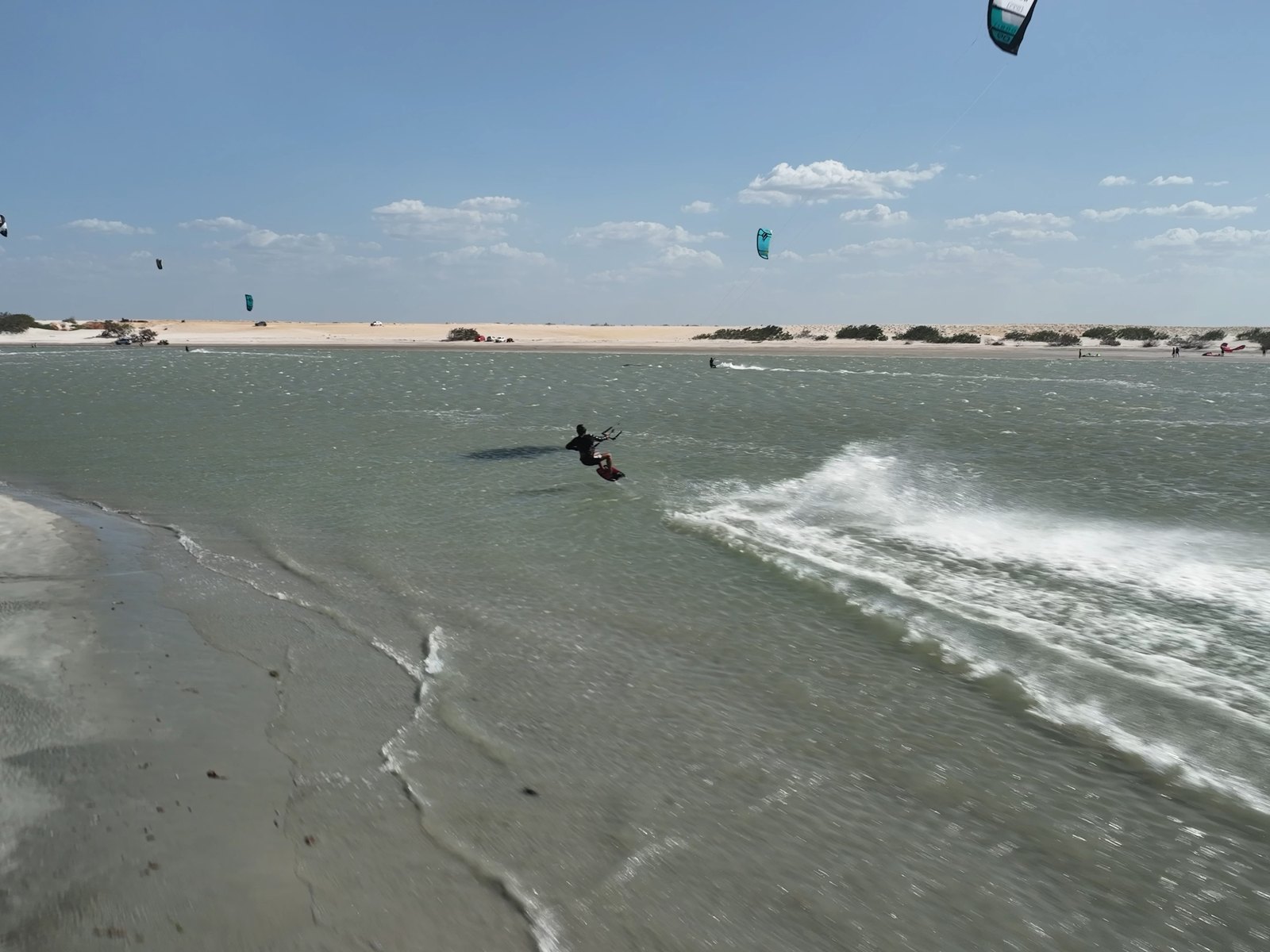 Riders navegando en el flat de Guriú, con varias cometas en el aire, en el corredor de Ceará
