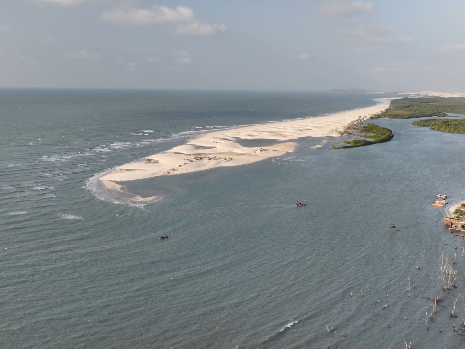 El río Guriú desembocando junto a la aldea, con la barra de arena al fondo
