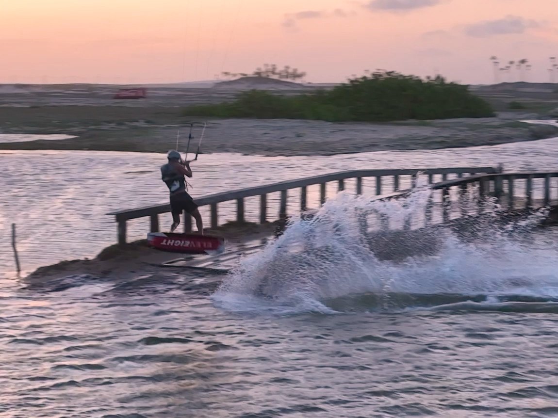 Rider saltando sobre el muelle de Jericoacoara al atardecer