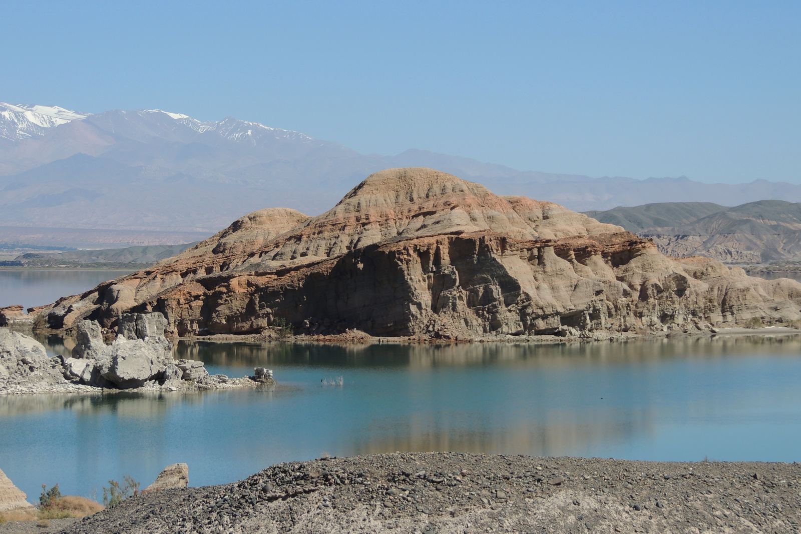 Promontorio de roca estratificada rodeado por el agua turquesa del embalse
