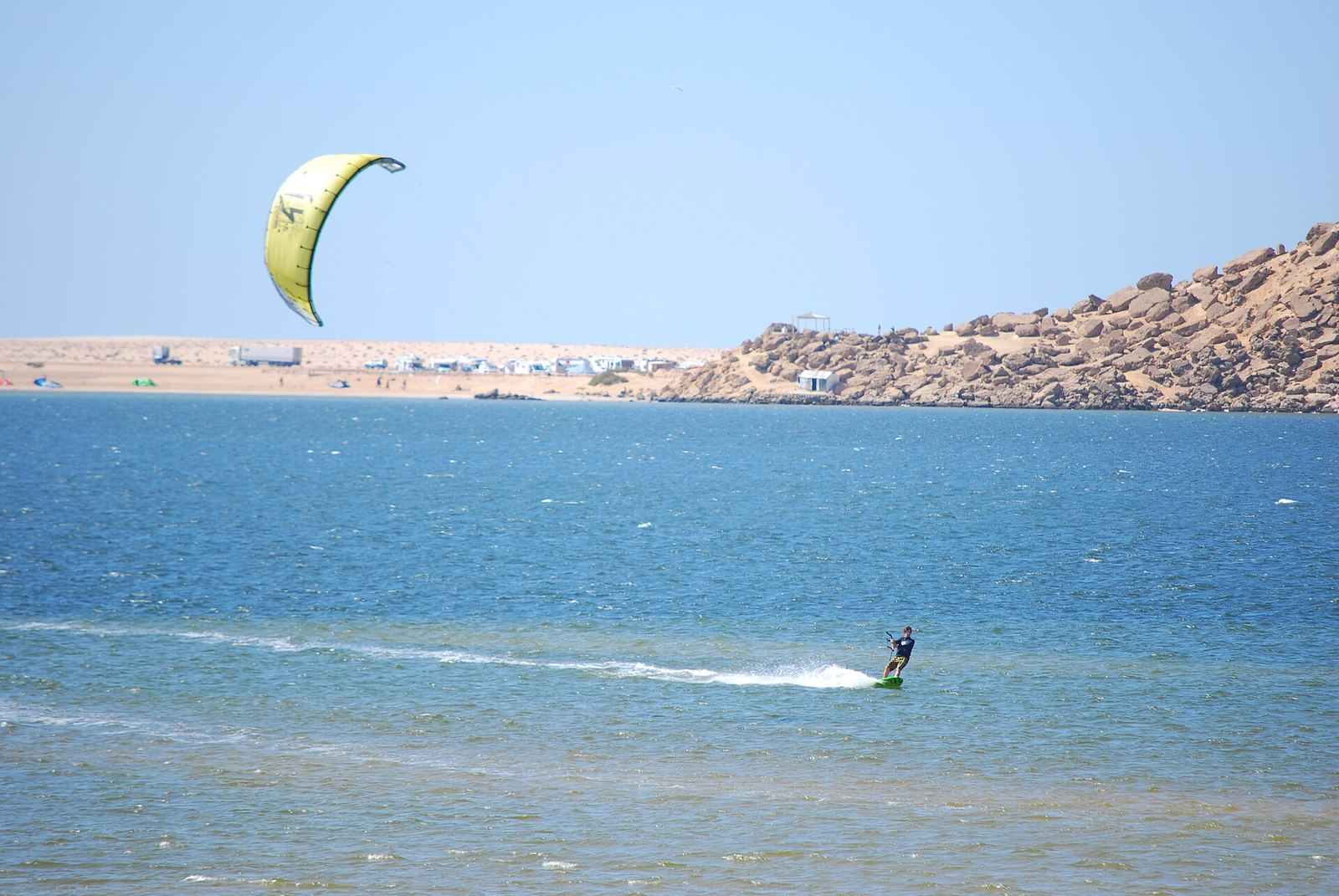 Rider en el agua plana de la laguna de Dakhla