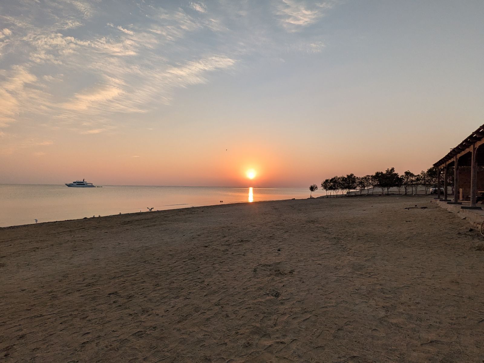 Amanecer en la costa del Mar Rojo con un barco de safari fondeado