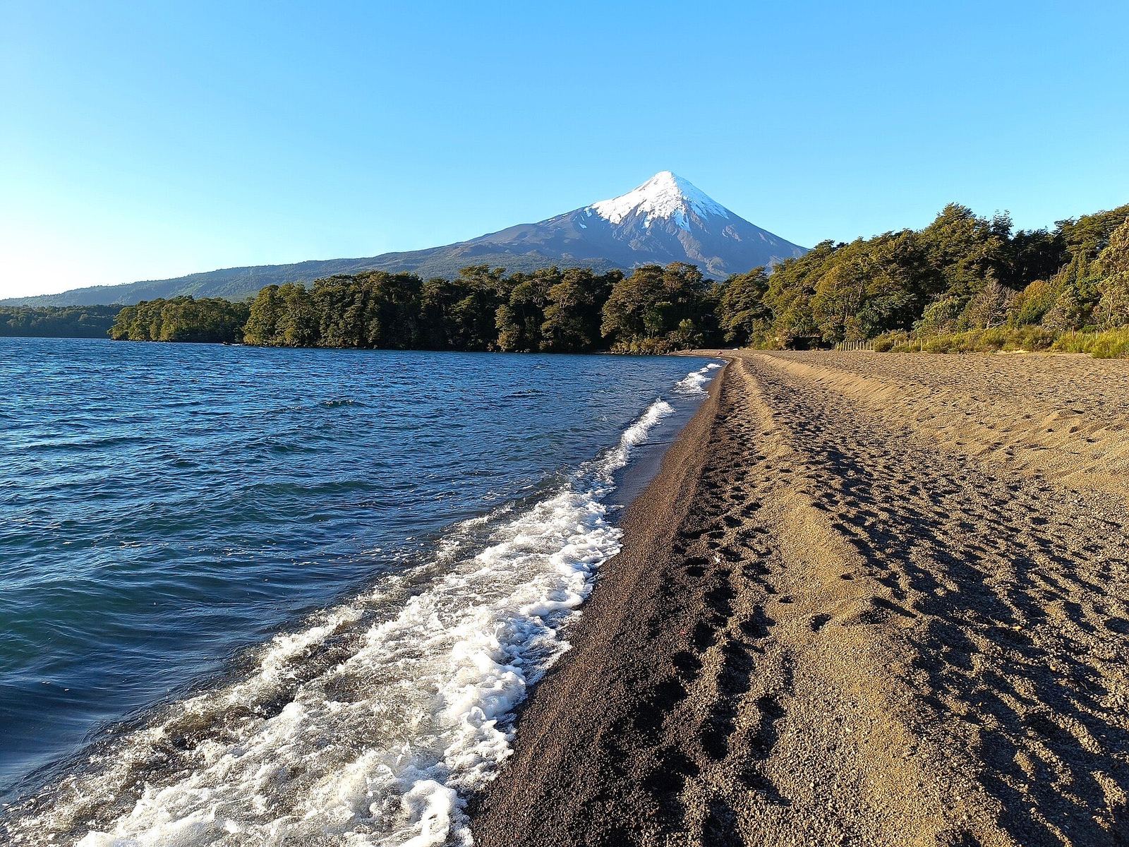 Playa de arena volcánica del Lago Llanquihue con el volcán Osorno nevado al fondo