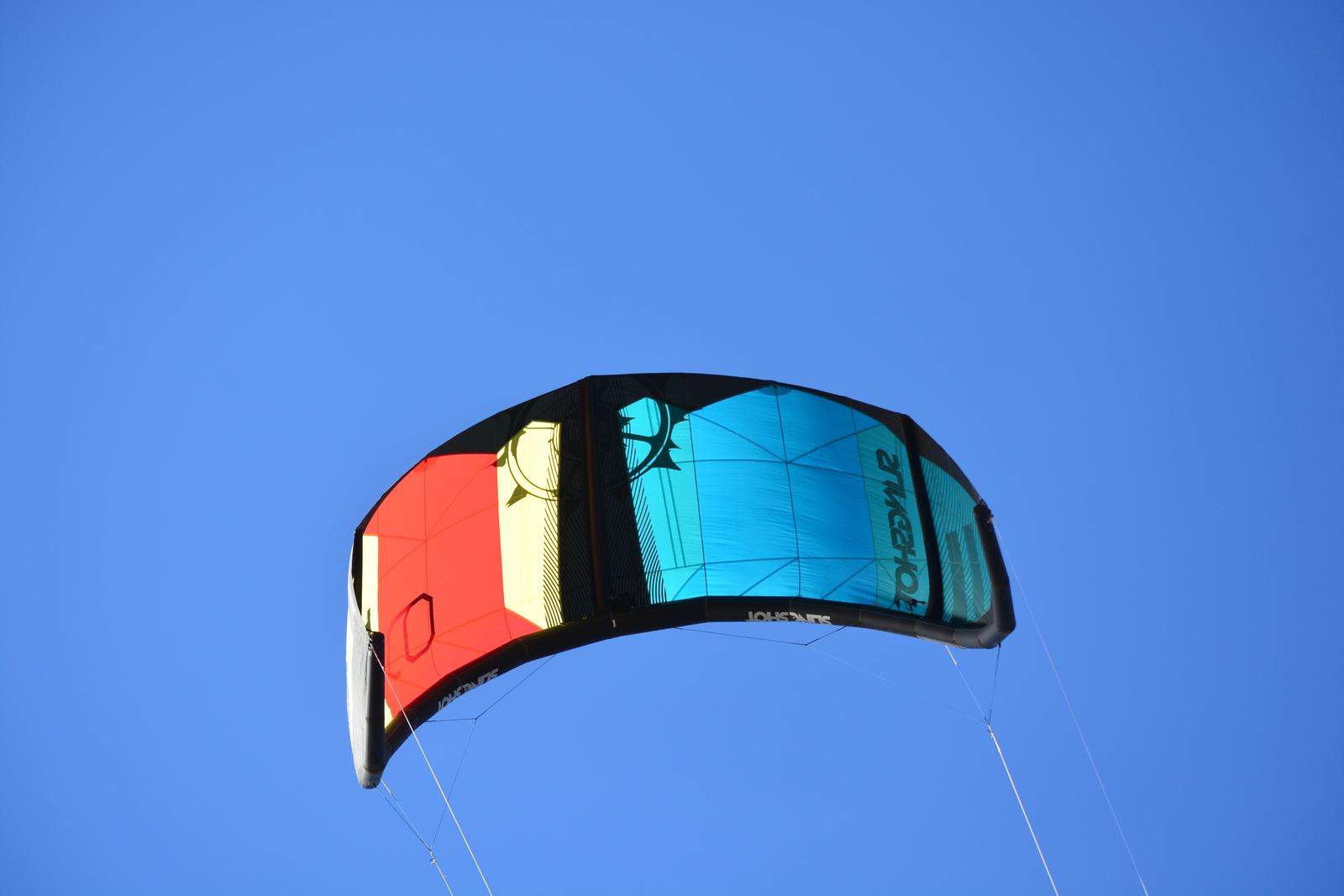 Cometa de kitesurf inflada volando contra un cielo despejado