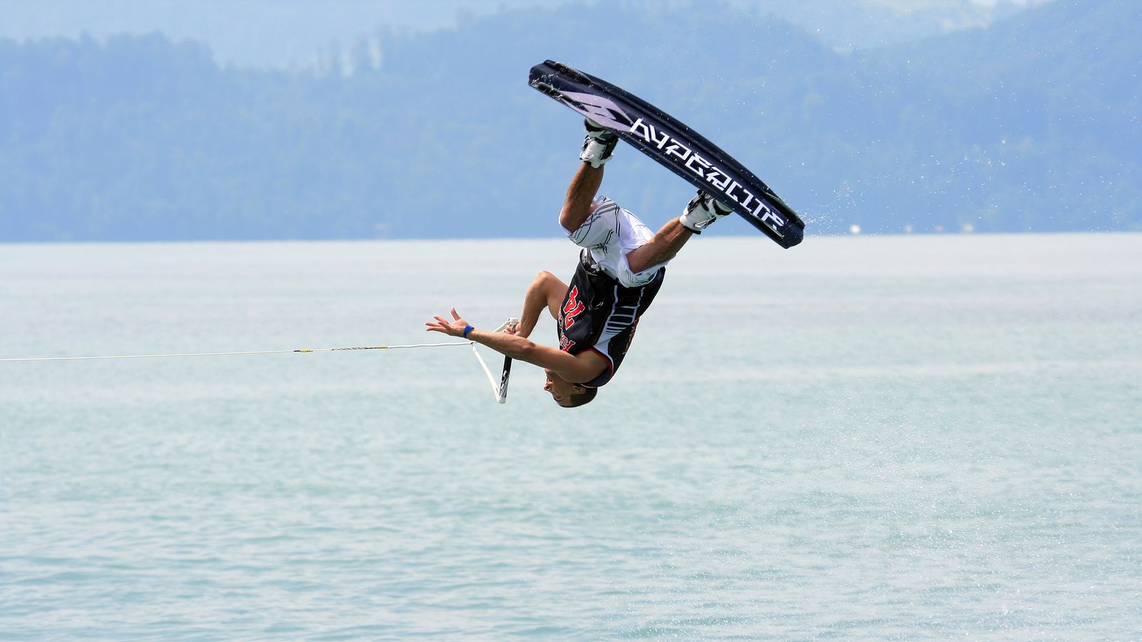 Wakeboarder en pleno salto sobre la estela de la lancha