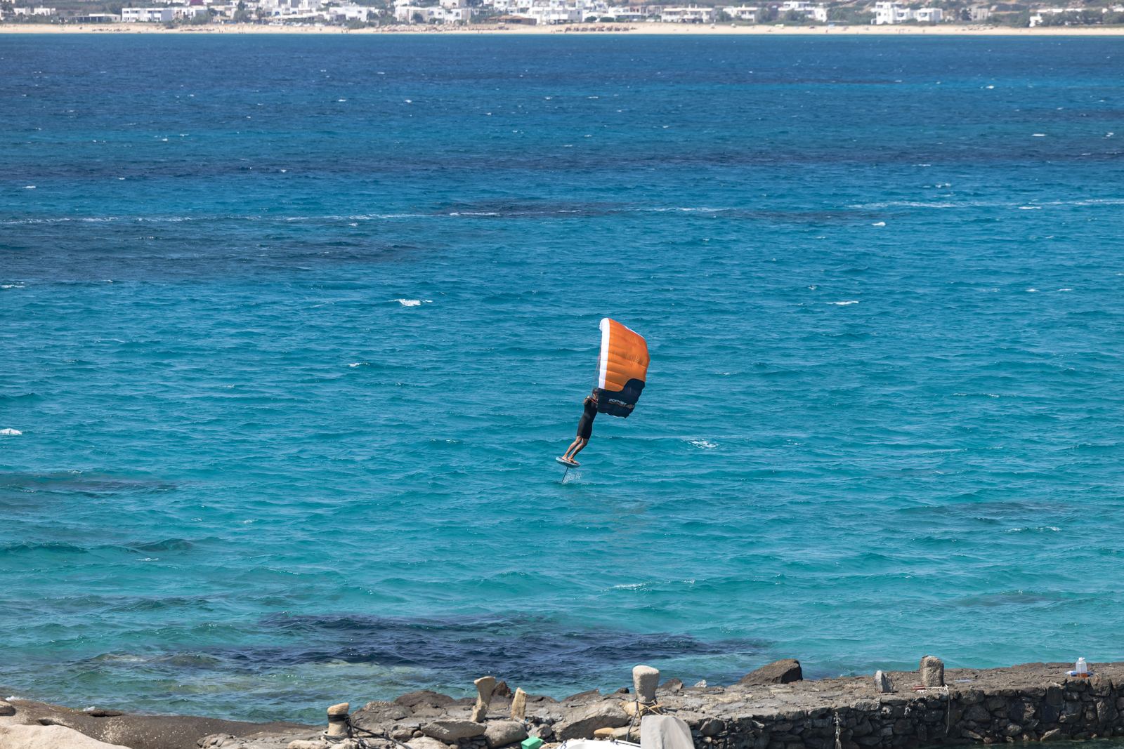 Rider navegando con un wing de mano sobre una tabla con hydrofoil